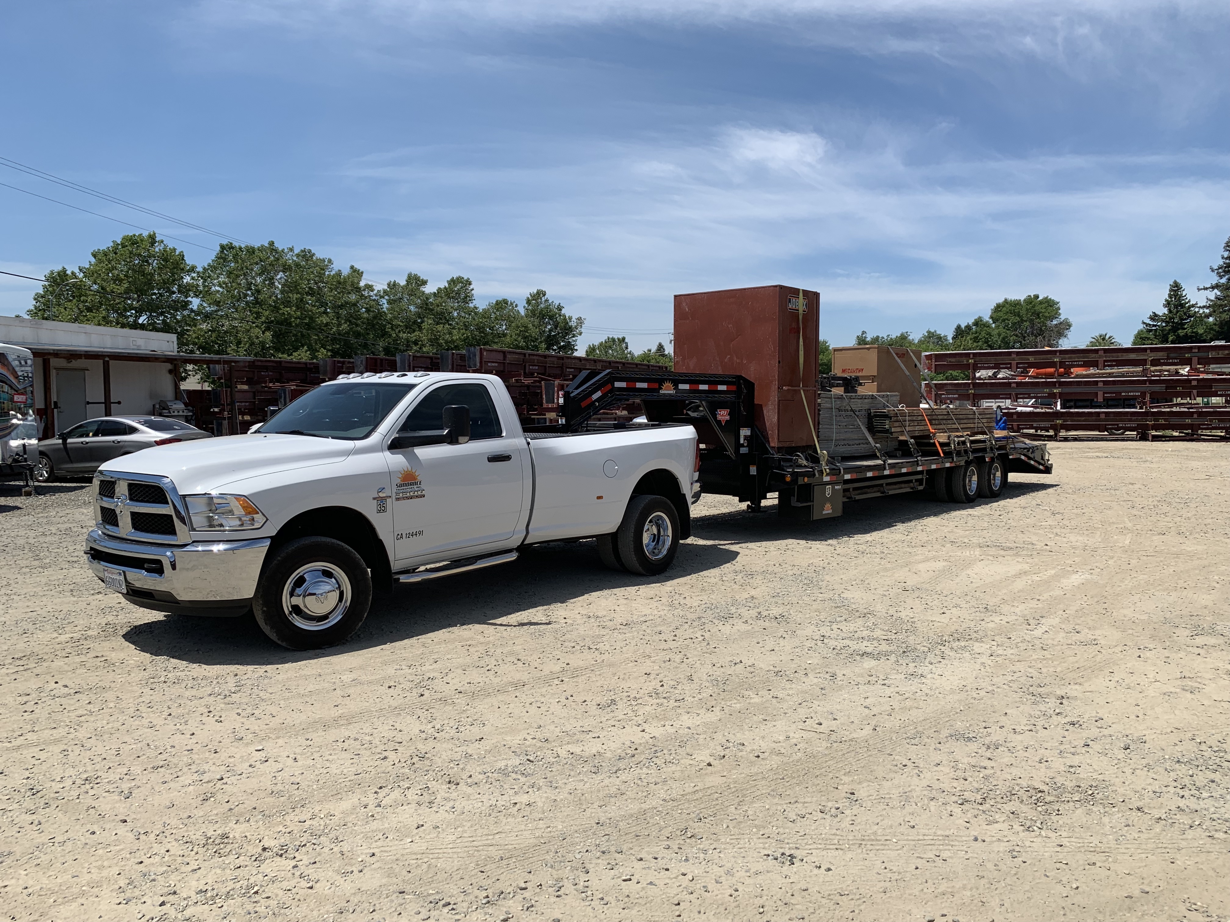 A hotshot truck with a loaded gooseneck trailer